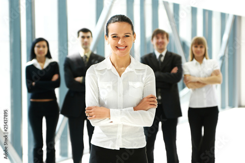 Five young business persons are standing as a team