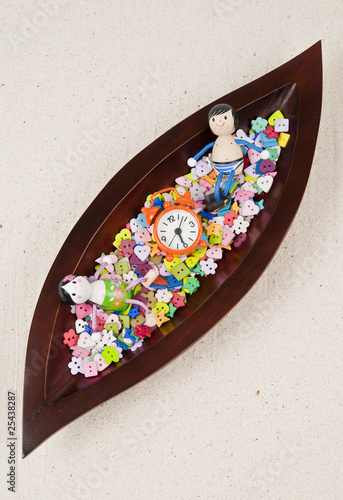 Children doll in the wooden leaf tray