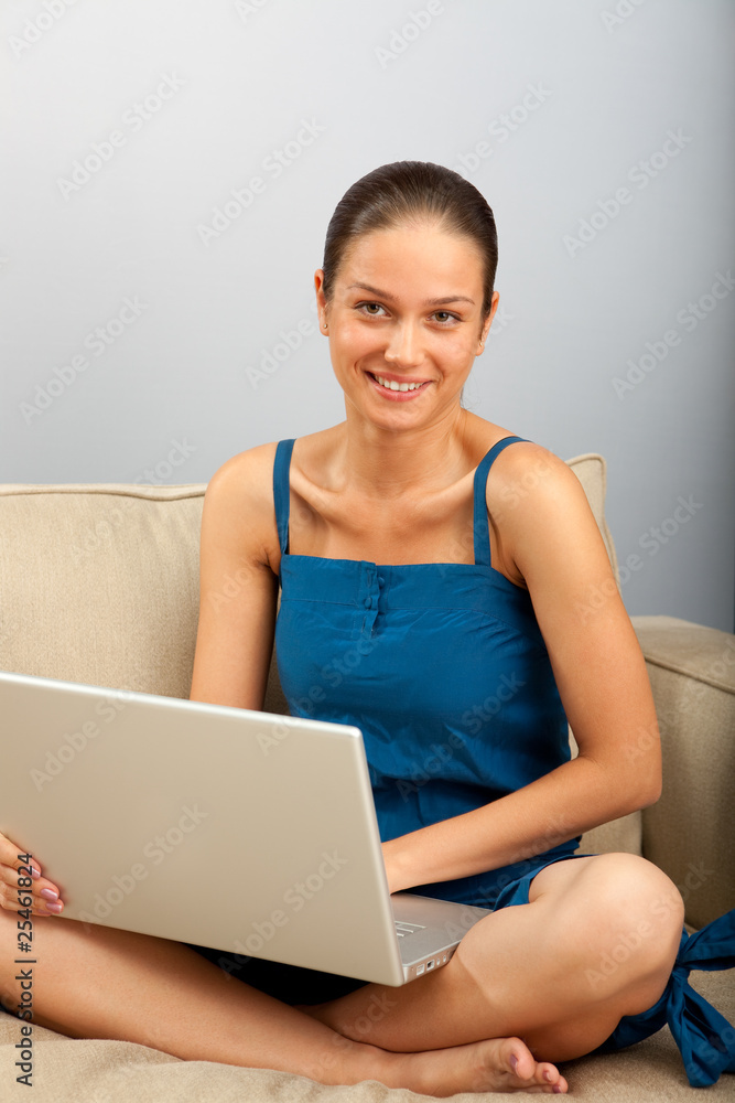 Young female sitting on the sofa with laptop Young female sitting on the sofa with laptop