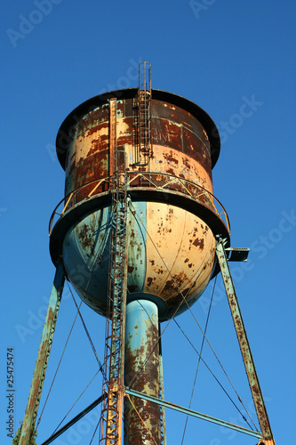 Old rusty watertower against blue sky