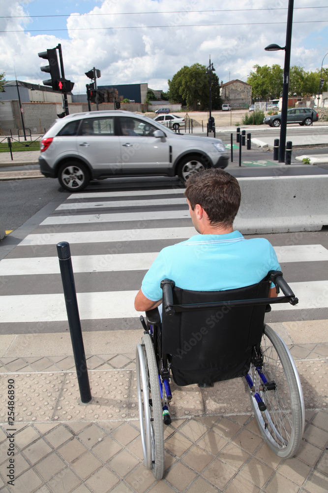 Obraz premium Young man using wheelchair in town