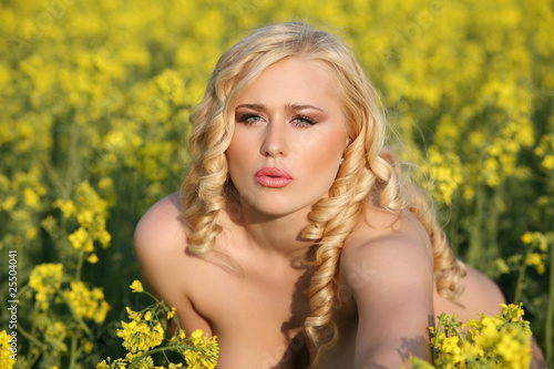 Beautiful young blonde woman in a field of wildflowers.