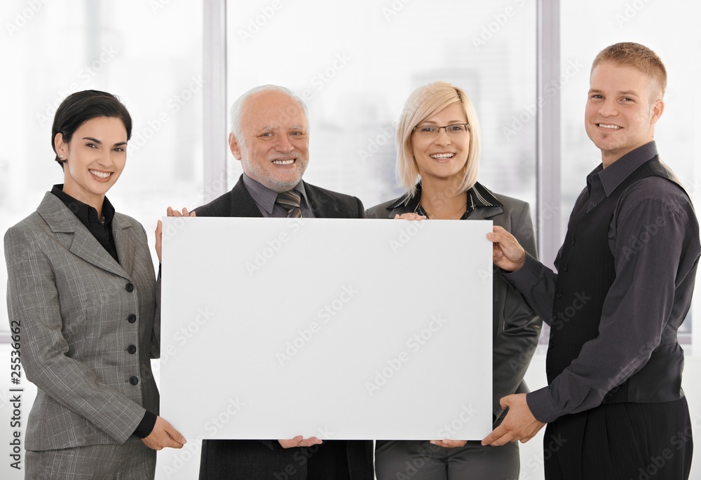 Businessteam holding blank poster Businessteam holding blank poster
