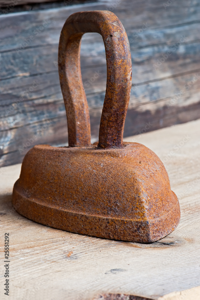 Old rusty iron over wooden background Old rusty iron over wooden background