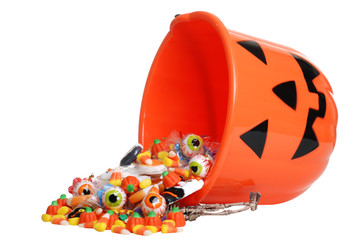 child halloween pumpkin bucket spilling candy