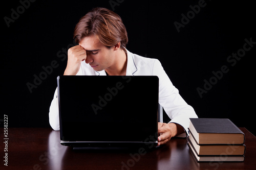 Tired young businessman on the computer