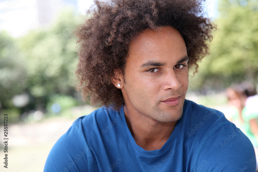 Closeup of young man sitting in a park Closeup of young man sitting in a park