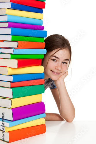 Student sitting behind pile of books on white #25587869