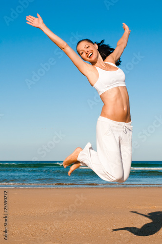 Frau springt am Strand photo