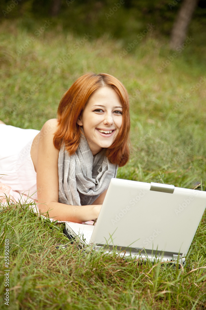 Young fashion girl with notebook lying at green grass Young fashion girl with notebook lying at green grass