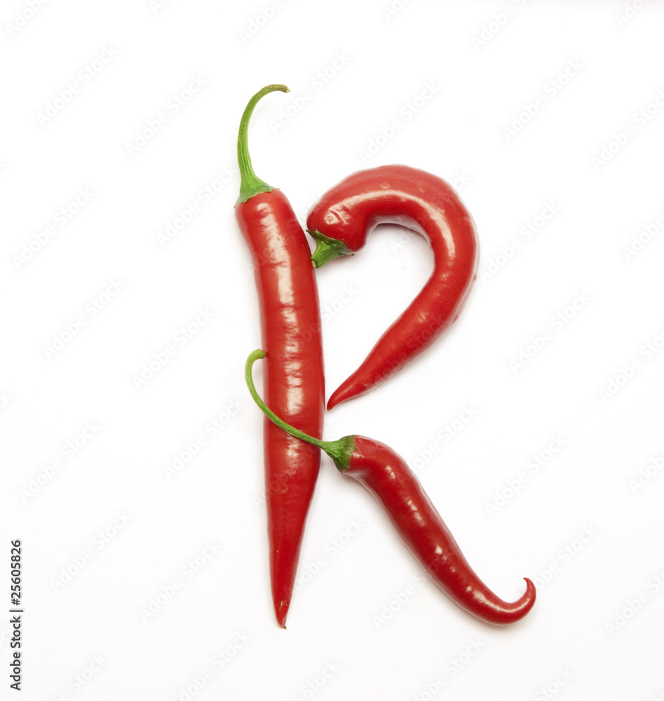 Letter made from red peppers over white backround