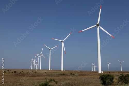 Row of wind turbines against a blue sky