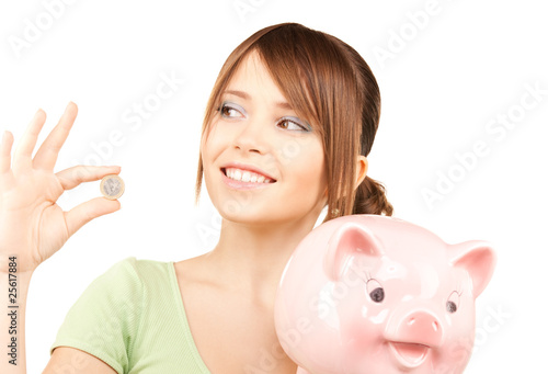 lovely teenage girl with piggy bank and coin