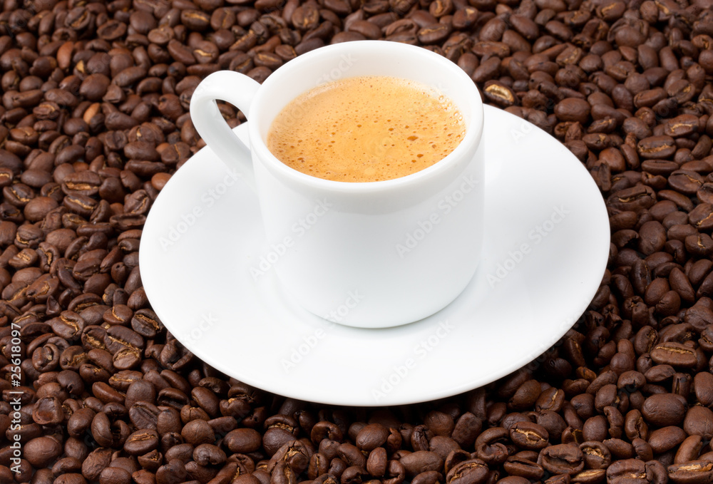 Fototapeta premium White espresso cup sat on coffee beans