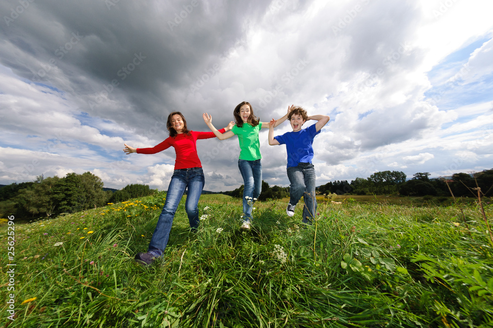 Active family - mother and kids jumping outdoor Active family - mother and kids jumping outdoor