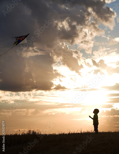 A young boy aims for the sky with his kite.