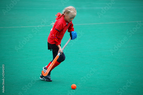 Field hockey girl running with ball photo