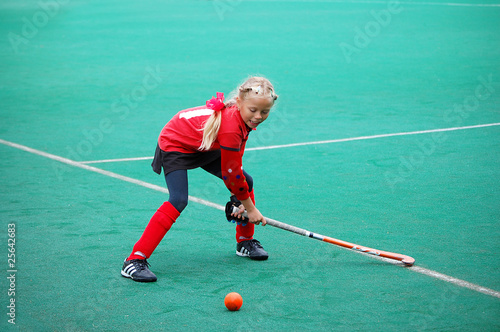 Field hockey girl poing to hit the ball