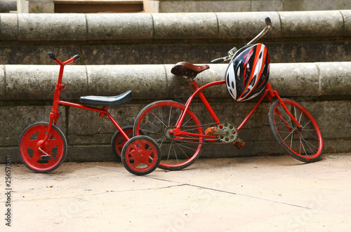 Two red retro bicycles and modern helmet