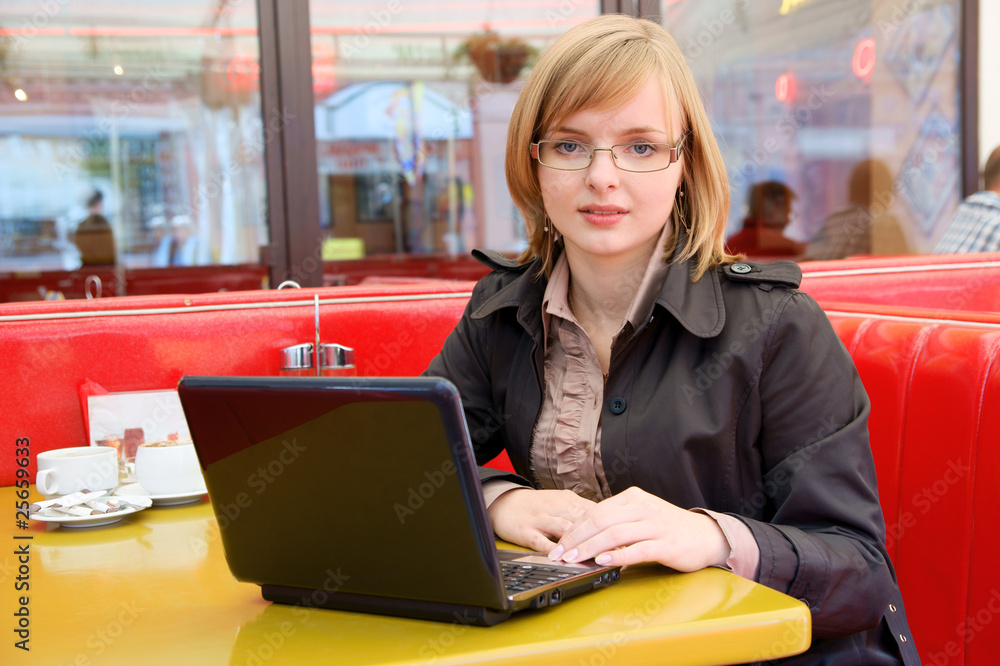 Business woman working on a laptop at cafe Business woman working on a laptop at cafe