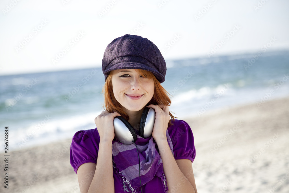 Portrait of red-haired girl with headphone on the beach. Portrait of red-haired girl with headphone on the beach.