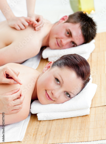 Charming caucasian couple receiving a back massage
