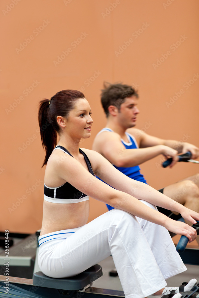 Athletic people using a rower