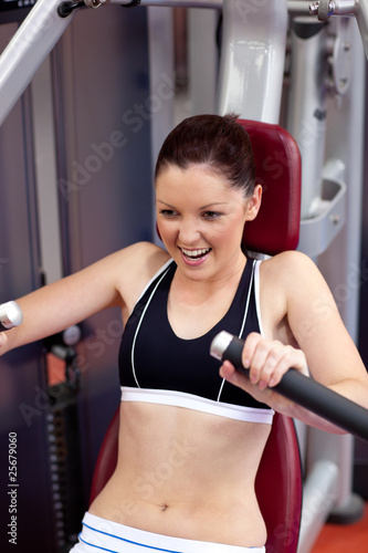 Charming athletic woman using a bench press