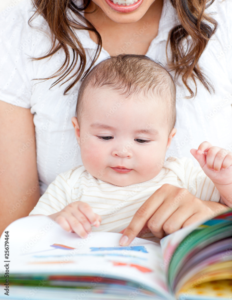 Bright mother showing images in a book to her cute little son Bright mother showing images in a book to her cute little son