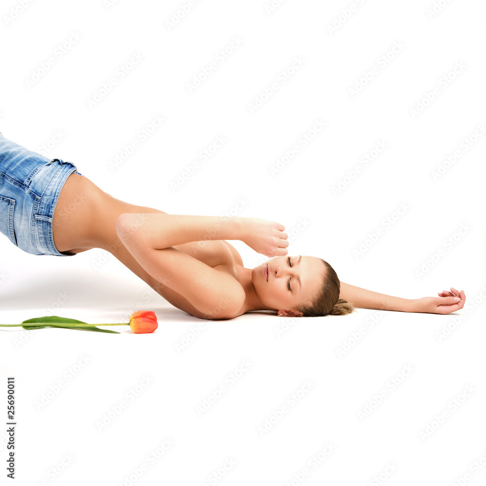 Fototapeta premium Fashion photo of young sensual woman in jeans with the tulip.