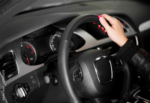 Women hand on the steering wheel of modern car