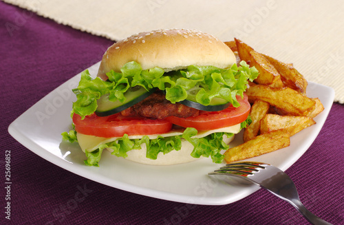 Hamburger with French fries and fork (Selective focus)