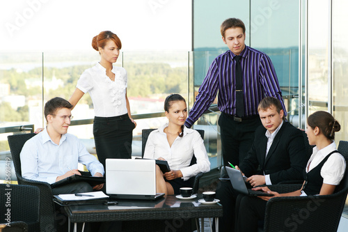 A group of six business persons is working on a meeting