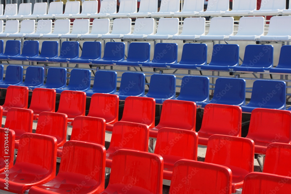 Fototapeta premium Rows of red, blue and white plastic chairs