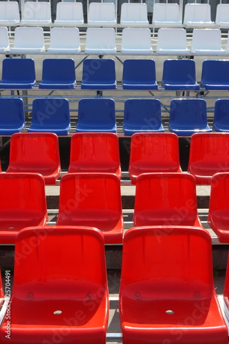 Rows of red, blue and white plastic chairs