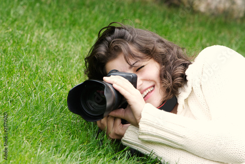 young girl taking picture on natural background photo