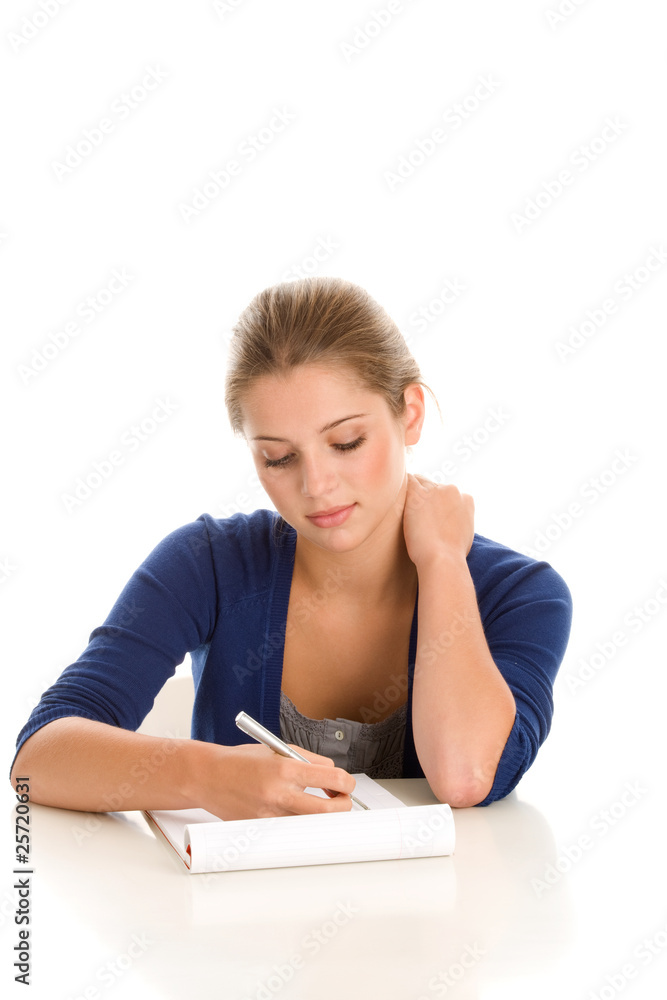Female student sitting behind desk with notepad and pen Female student sitting behind desk with notepad and pen