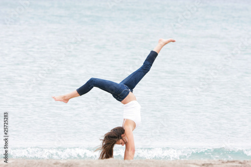young girl doing gymnastics on sea background