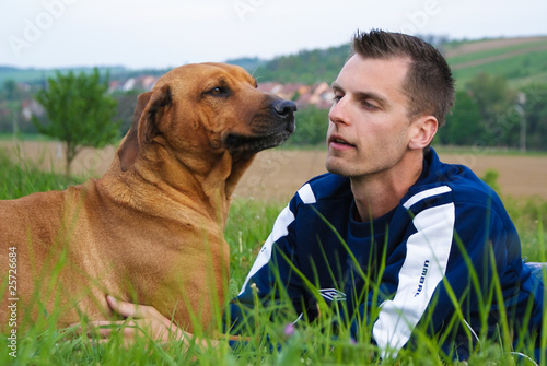 Young man and his dog in nature