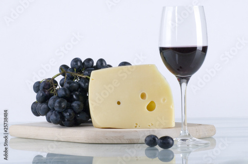 Glass of red wine with grapes and cheese