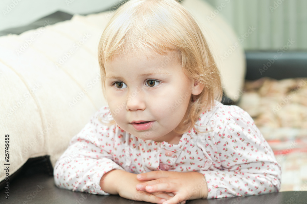 Little child a blond girl sitting on couch Little child a blond girl sitting on couch