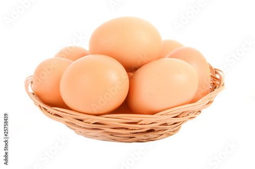 Group of brown hen's eggs in the braided backet isolated in whit