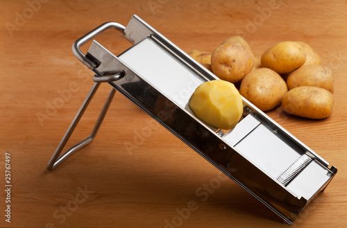 eine halbe Kartoffel auf einer Mandoline photo
