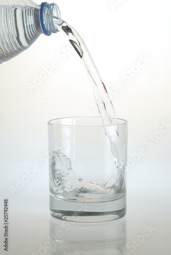 Vaso de agua y botella vertiendo