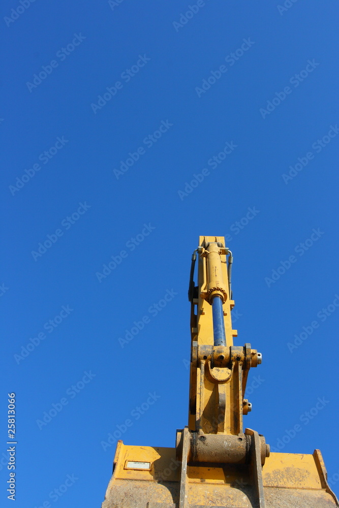 Hydraulic excavator arm against a blue sky Hydraulic excavator arm against a blue sky