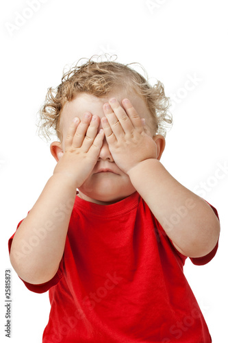 Baby covering eyes with hands playing peekaboo isolated on white