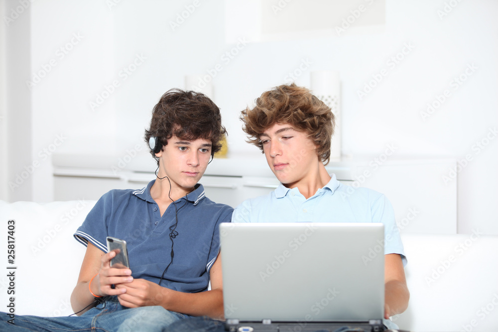 Teenagers with music player and computer at home Teenagers with music player and computer at home