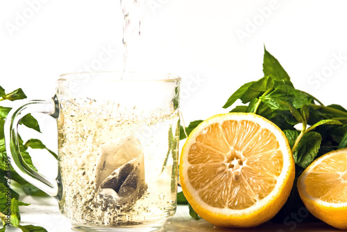 Tee wird in Glas eingegossen mit Zitrone