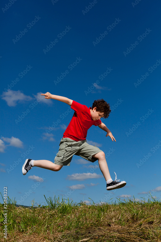 Boy jumping, running against blue sky Boy jumping, running against blue sky