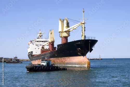 cargo ship and cutter in seaport water area